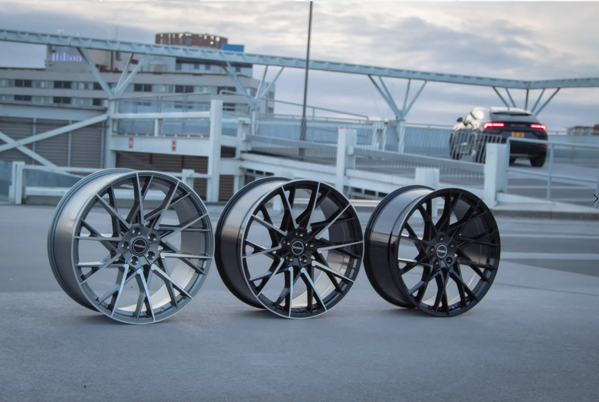 Three Riviera alloy wheels lined up on a rooftop car park